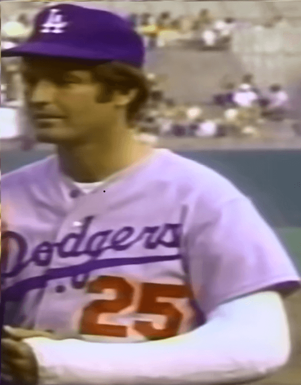 Tommy John in 1974 Dodgers blue road uniform, left arm in cast post-UCL surgery—captured during the era when he worked with Dr. Mike Marshall on biomechanics and pitching reform.