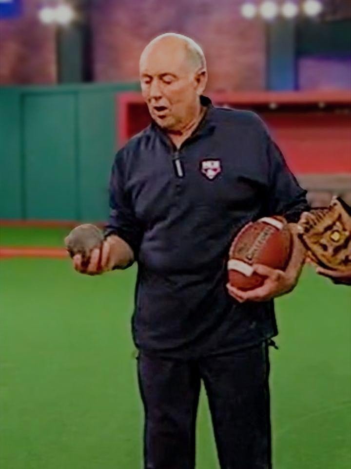 Dr. Mike Marshall holding iron ball and football during pitching motion explanation on MLB Network (2009), used for instructional purposes