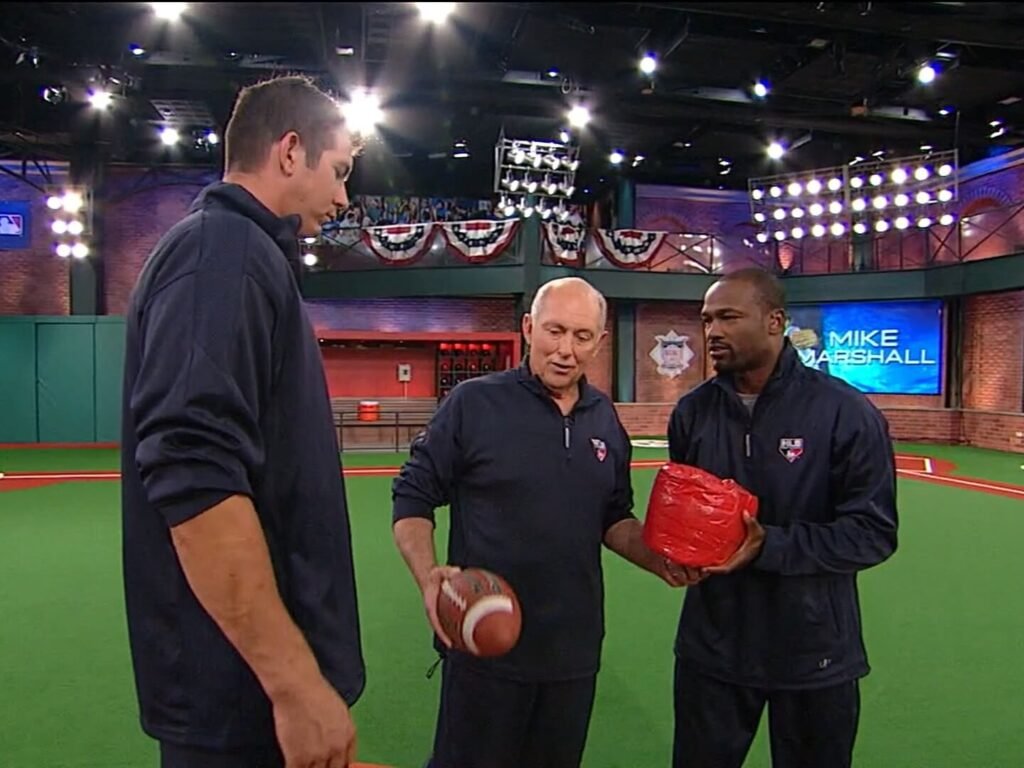 Dr. Mike Marshall demonstrating wrist weight training with pitcher Joe Williams and host Harold Reynolds on MLB Network Studio 42 in 2009, used for instructional purposes.